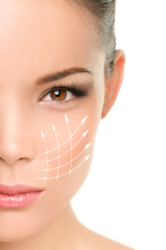 Face lift anti-aging treatment - Asian woman portrait with graphic lines showing facial lifting effect on skin.